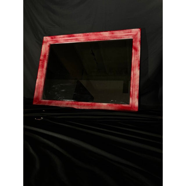 Rectangular wall mirror with a layered frame in a distressed red finish. The finish was applied by hand in the LOOM...