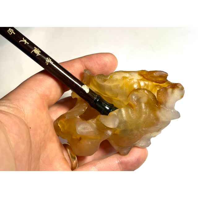 This hand carved carnelian agate brush washer exemplifies traditional Chinese scholar's desk accessories that became...