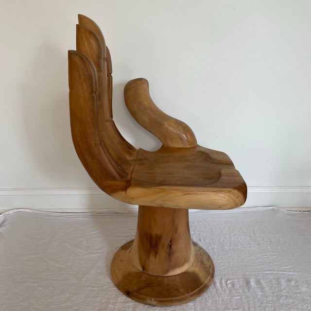 A Buddha or hand chair .The chair is in a carved wood. The chair is a literal representation of the Asana pose in Buddhism...