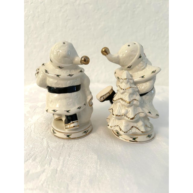 Charming vintage ceramic salt and pepper shakers in a figural Santa motif adorned with delicate holly berries and gold...