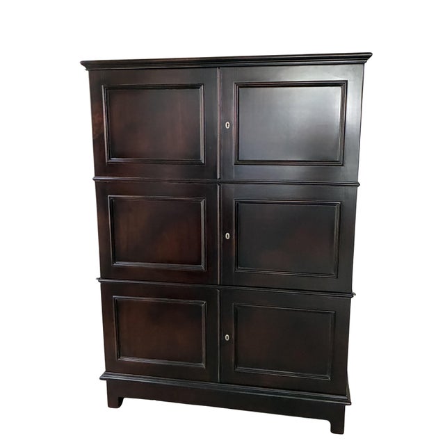 Exceptional Baker Furniture “Milling Road” Hildebrand armoire or storage cabinet crafted in a rich dark mahogany finish...