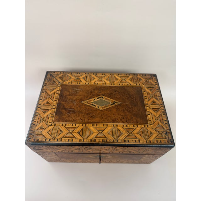This Antique Marquetry Inlaid Wooden Jewelry Box is a beautifully crafted piece with a geometric pattern. It may be...