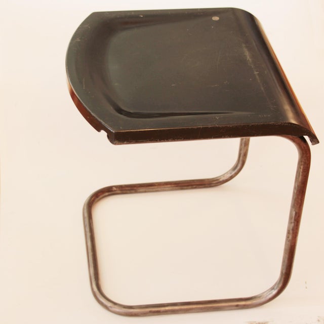 Tubular steel stool with a bakelite seat, designed in a style reminiscent of Rene Herbst's chairs.