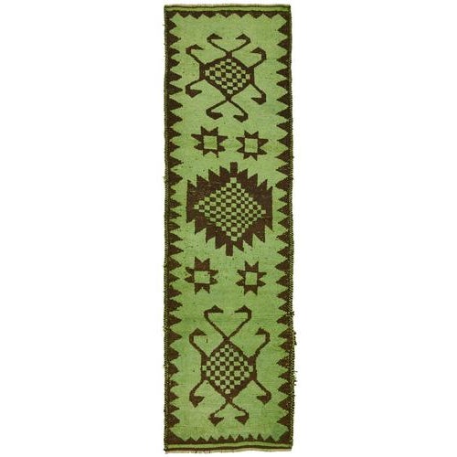 This exquisite runner rug is a rare example of tribal craftsmanship, hand-knotted by the women of the Herki tribe during...