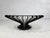 Round coffee table with an airy bronze-colored metal frame and a transparent glass top