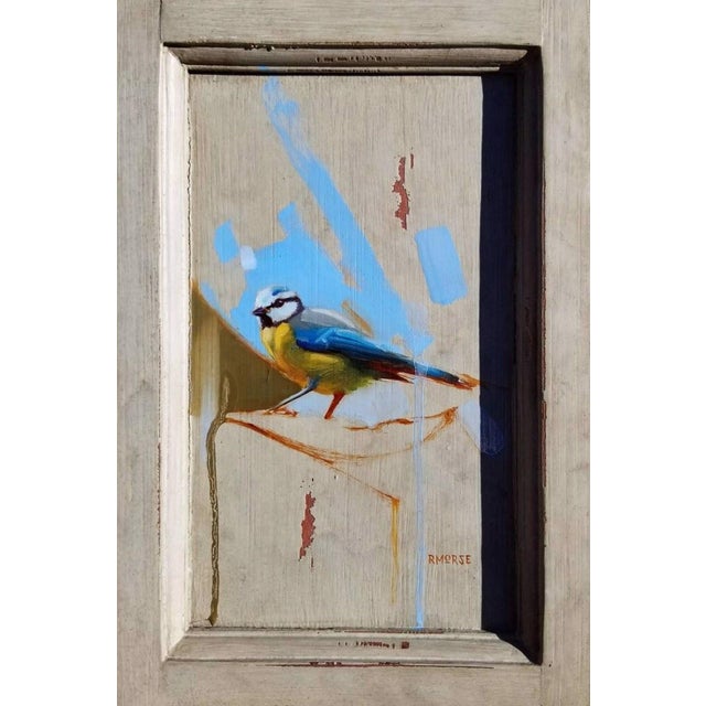 This oil painting captures a bird perched with a striking blend of blue and yellow hues that evoke a sense of tranquility....