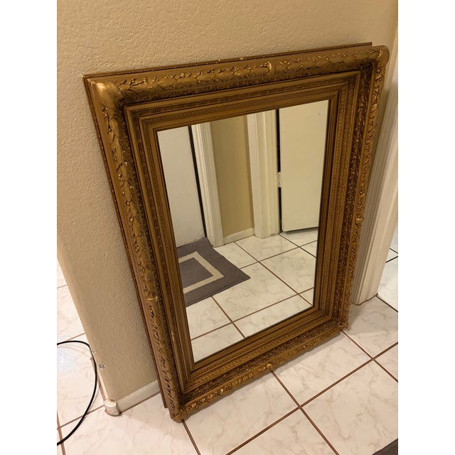 Beautiful substantial mirror featuring an elaborate antique-style gold gilt frame with intricate leaf, berry and floral...