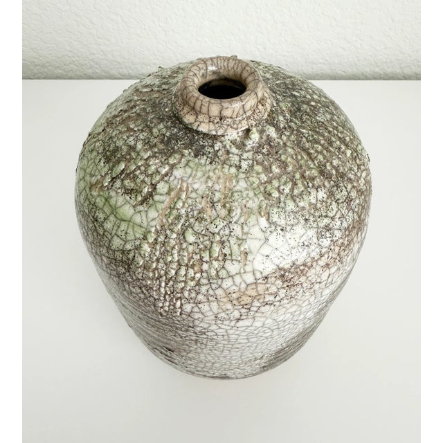 Beautiful, large ceramic raku vase featuring off-white and black crazing with a drip accent glaze in a celery green around...