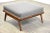 A mid century modern walnut color ottoman designed by T.H. Robsjohn Gibbings. Professionally refinished and reupholstered...