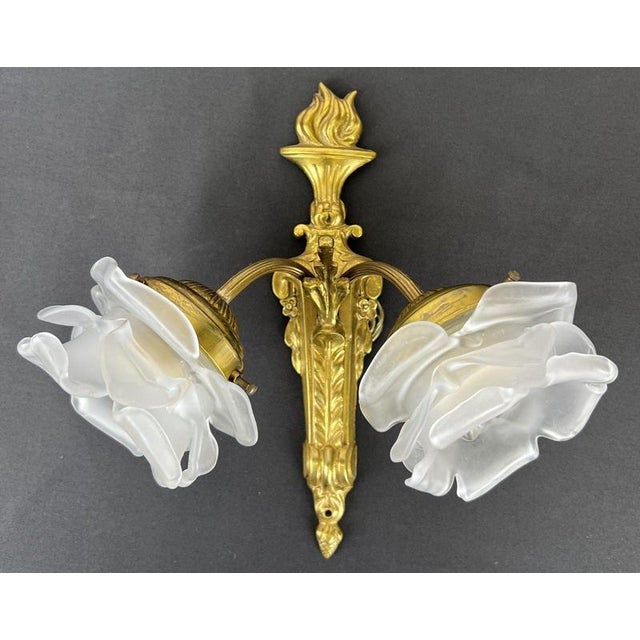 A decorative Vintage French pair of wall sconces , each featuring a twin-arm design with flower-shaped glass shades and an...