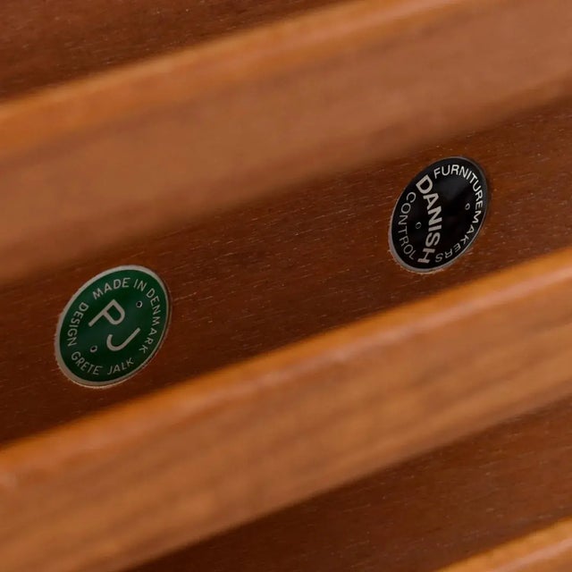 Pair of handsome Danish teak side tables by celebrated designer, Grete Jalk. The end tables feature slatted racks beneath...