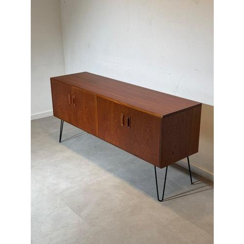 Authentic mid-century modern sideboard produced by G-Plan , crafted in richly grained teak wood and raised on elegant...