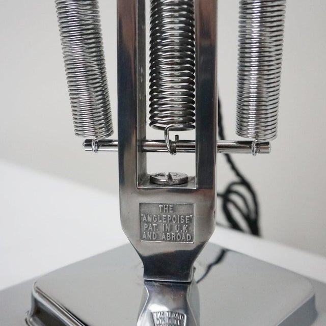 Three-spring' chromed and polished metal anglepoise desk lamp by herbert terry & sons. Two step base and perforated lamp...