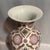 A large scale pink and pastel with gold trim ginger jar form heavy porcelain decorative vase with medallion style design....