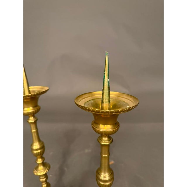 Pair of 19th-century French Gothic style bronze candelabra dating to circa 1890, featuring intricate cast cherub motifs...
