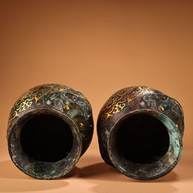 A handsome pair of Chinese bronze jars, decorated with intricate gold inlay (错金, "cuojin") scrollwork and inscriptions...