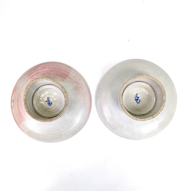 Beautiful stem dishes with a cherry blossom design at the top. One has a pinkish hue. There is a hairline crack .Both have...