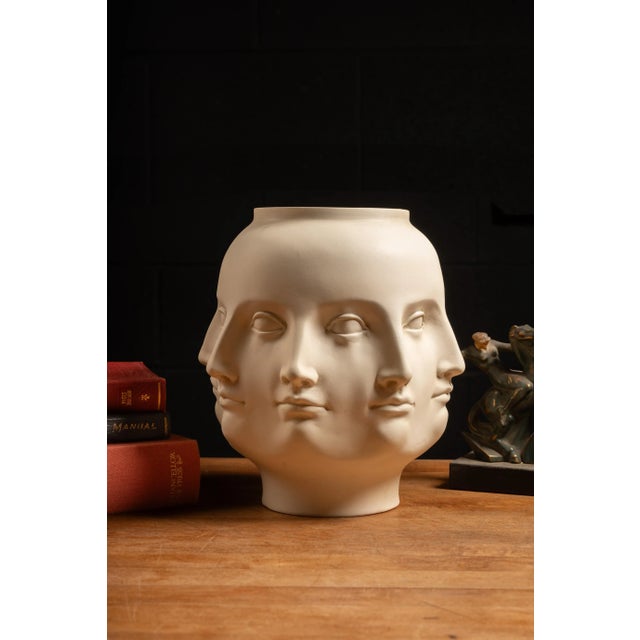 Stamped "TMS 2005" Fornasetti style, Vitruvian-inspired resin mold vase. This piece features eight perpetual faces, all...