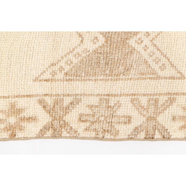 This is a vintage Turkish Oushak rug from the Mid 20th Century. The piece was hand-knotted.