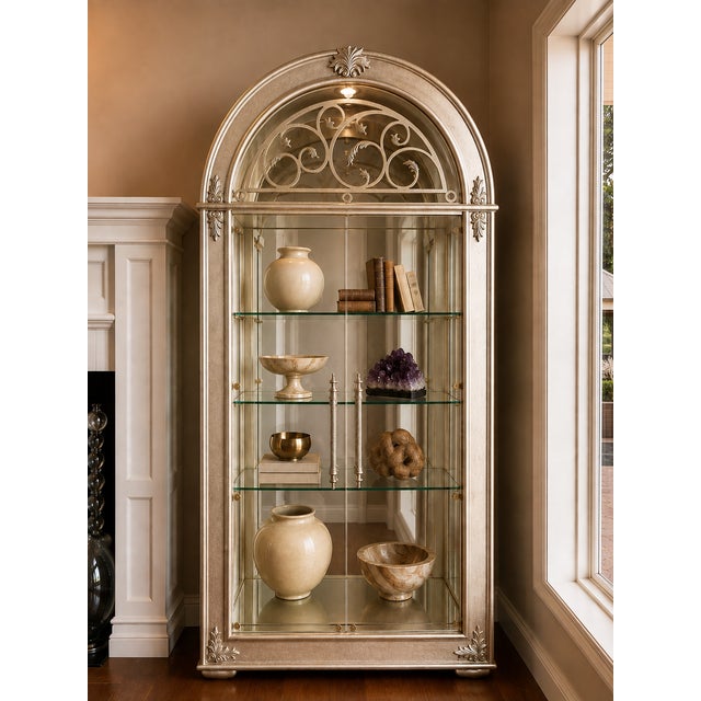 A monumental gold and silver leaf display vitrine by Henredon, featuring an elegant architectural iron arch, decorative...
