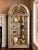A monumental gold and silver leaf display vitrine by Henredon, featuring an elegant architectural iron arch, decorative...