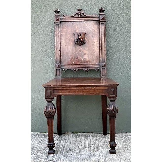 Exude an air of timeless dignity with this stately vintage English hall chair, a fine example of Gothic Revival...