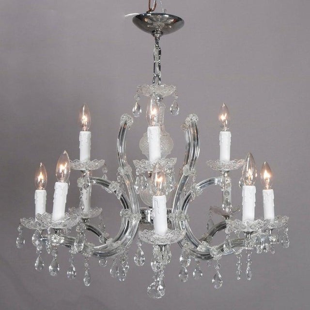 A vintage Italian crystal chandelier offers chrome frame having twelve scroll form arms terminating in candle lights,...
