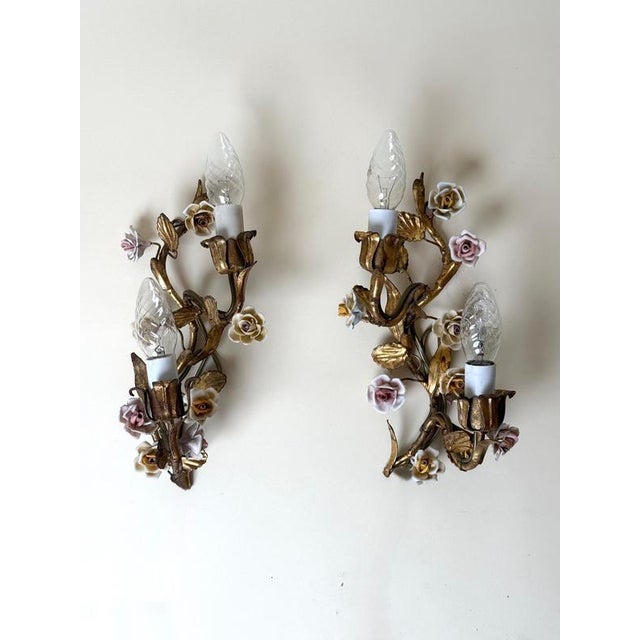 An exceptionally delicate and decorative pair of italian two-light wall sconces, dating approximately from the 1930s to...