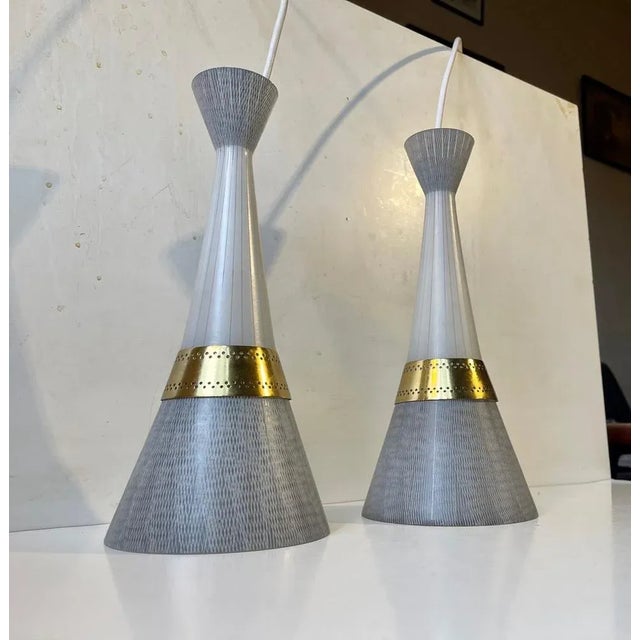 Stylish pair of Diablo shaped hanging lamps in glass and brass. The glass features hand-engraved patterns derived from the...