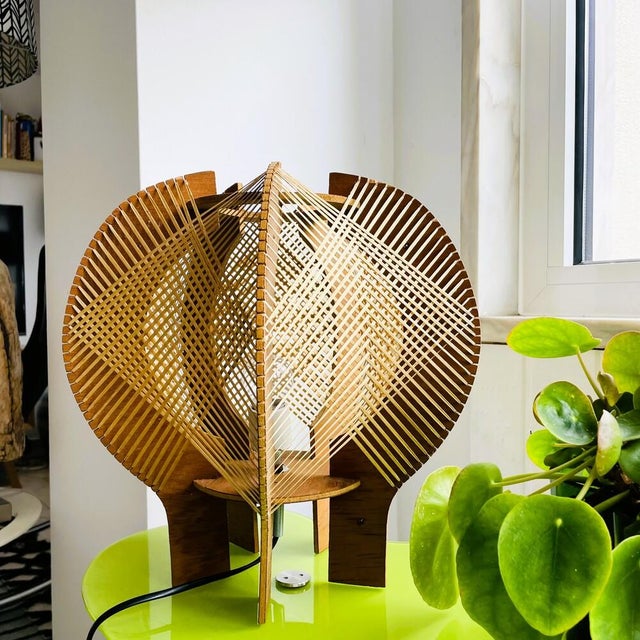 Sculptural table lamp from the 1960s-70s, made of plywood and a straw-like material. Provides warm ambient lighting....