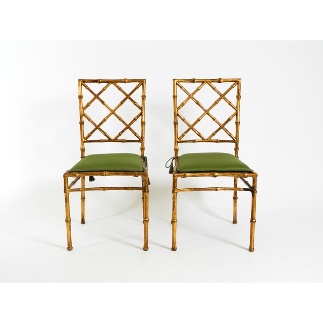 A pair of beautiful Regency-style metal chairs from the 1970s, featuring a faux bamboo design with a gold-tone finish....