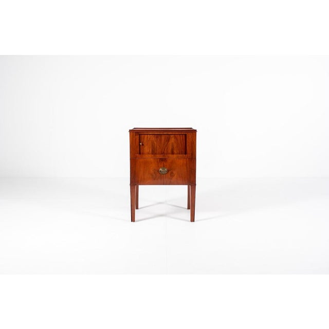 Beautiful antique bedside cabinet with roller door, standing on tapered legs. The top features a small, original raised...