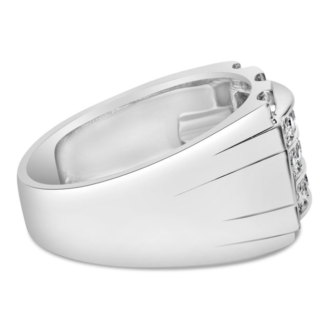 Enwrap your finger in the luminous elegance of this .925 Sterling Silver 1/4 Cttw Diamond Three Row Channel Band Ring, a...