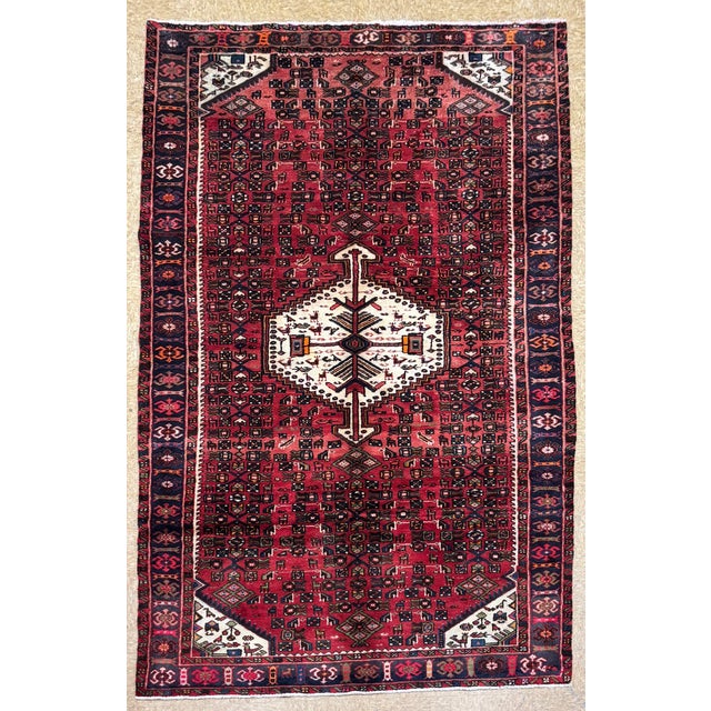 Antique hand-knotted rug from the Hamedan region of western Iran, featuring a dense all-over geometric pattern arranged...