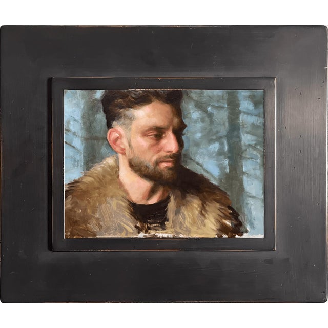 In "Fire Starter," a figure emerges against a soft, blurred backdrop of trees, exuding a sense of quiet intensity. The...