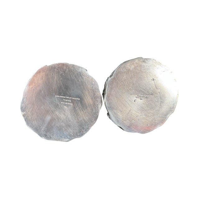 Pair of Tiffany & Co. sterling silver candle holders by Louis Comfort Tiffany with curvilinear wave motifs. Measure 3 1/3”...