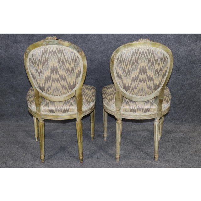 A refined and elegant pair of French Louis XVI style side chairs, beautifully crafted with neoclassical restraint and...