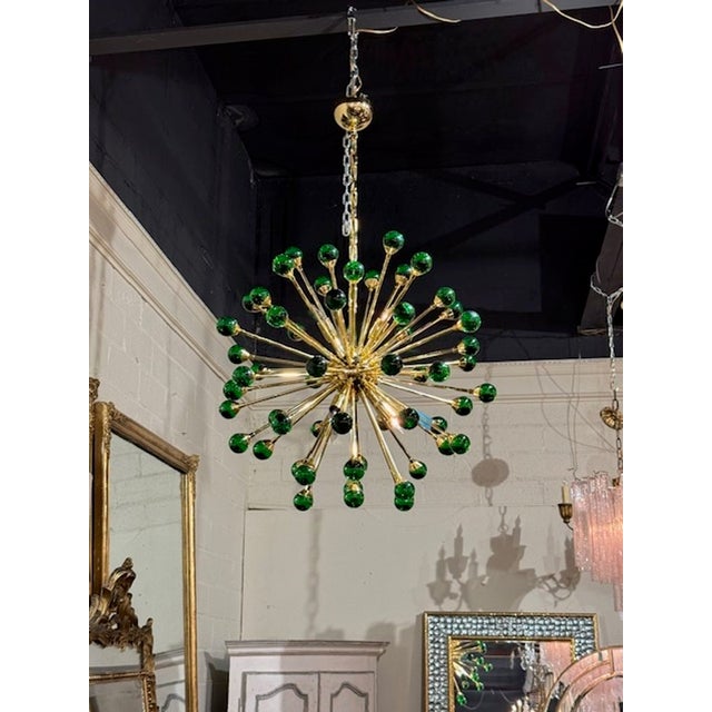 The "Modern Green and Brass Sputnik Chandelier" features a modern Murano design with a sleek brass frame, adding a touch...
