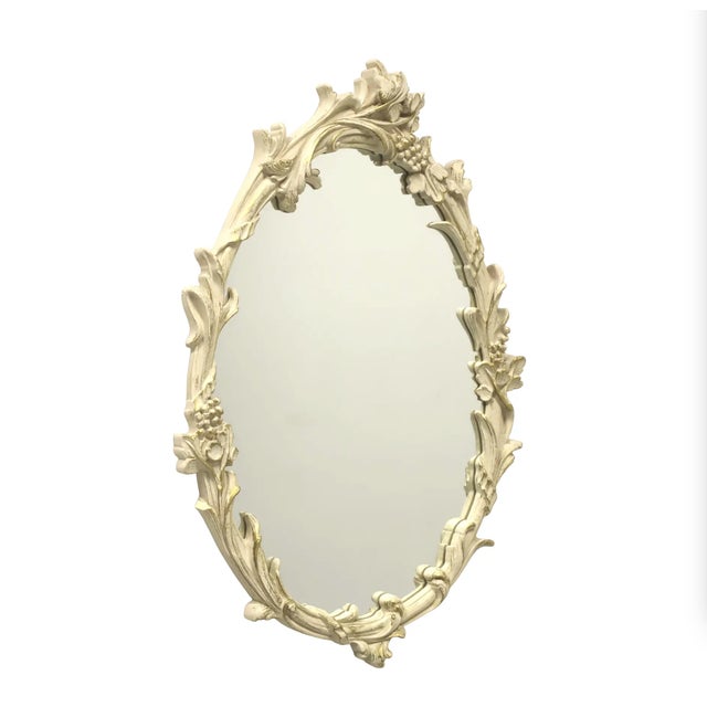 Delightful cream oval wall mirror with old gold highlights featuring flowers, berrries/grapes and swirls made by the...