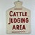 Its beauty is in its shape, simplicity, and subject matter. A hand made barn country sign declaring the "Cattle Judging...