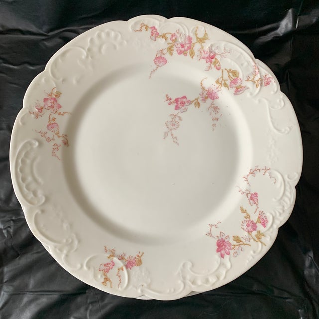This is a vintage dinner plate set produced by Haviland & Company in Limoges, France, featuring a pink floral swag...