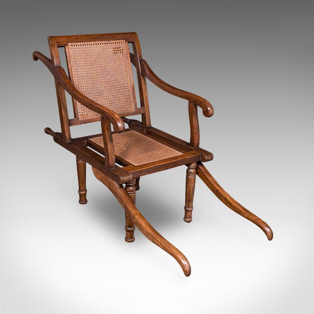 This is an antique ladies Colonial veranda chair. An English, beech and cane extending carrying seat, dating to the late...