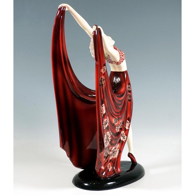 Delicate goldscheider art déco ceramic figurine of the late 1930s: gracefully posing dancer in a dark red costume: dotted...