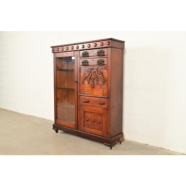 A gorgeous antique Victorian smoker's display cabinet with drop-front desk In the manner of R.J. Horner & Co. USA, Circa...