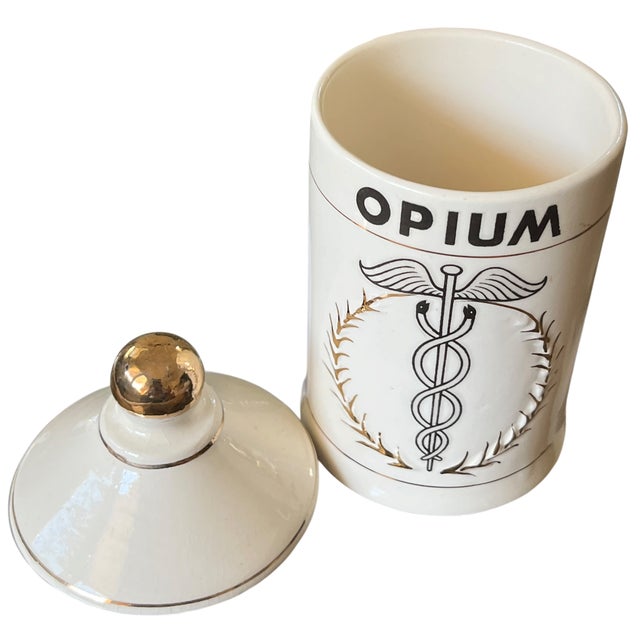 A wonderfully eccentric mid-20th century porcelain apothecary canister marked “OPIUM,” featuring a caduceus motif framed...