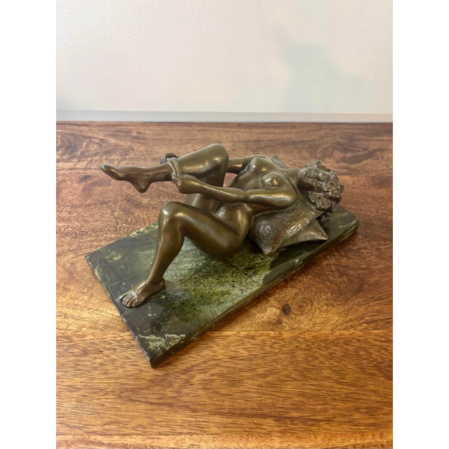 An elegant and finely detailed bronze sculpture by Louis Chalon depicting a reclining nude woman in the intimate act of...