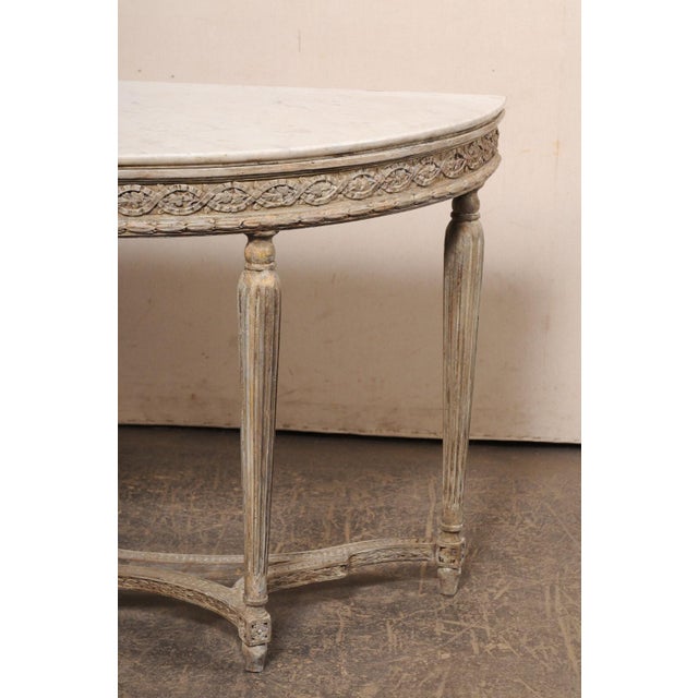 A French Neoclassic style carved-wood console table, with its original marble top, from the turn of the 18th and 19th...