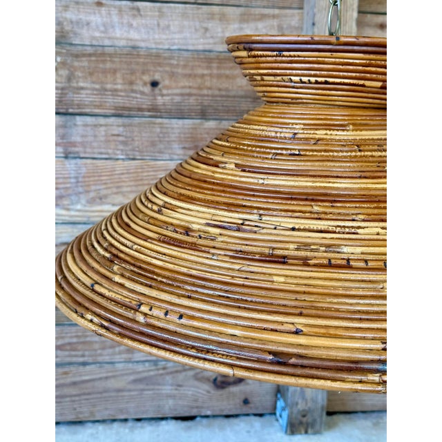A wonderfully sculptural vintage pendant light handcrafted from tightly coiled rattan in a warm natural finish. The...