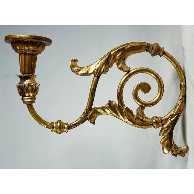 Important pair of wrought iron wall torch holders with turned wooden parts gilded with gold leaf made in the louis xv era....
