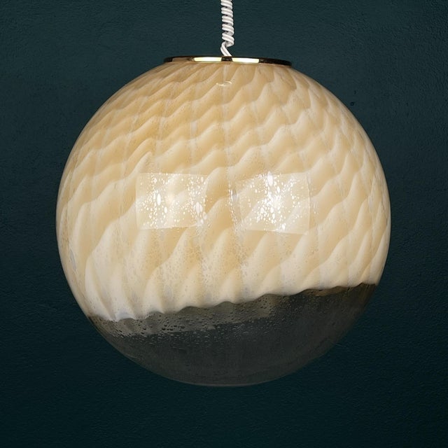 A magnificent large glass globe pendant light by veart from murano was made in italy in the 1960s. Transparent at the...